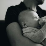 un homme qui donne le biberon à un bébé